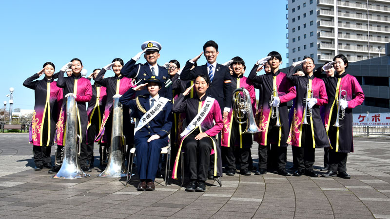 春の全国交通安全運動に合わせた四街道署の啓発活動に協力した千葉敬愛高校マーチングバンド部の谷岡部長(前列右)や美術部の陸田部長(同左)ら=四街道市の都市広場