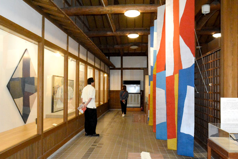 田園の美術館で開かれている特別展「旌旗蔽空」。ミズさんの色鮮やかなフラッグ5枚も紹介している=いすみ市