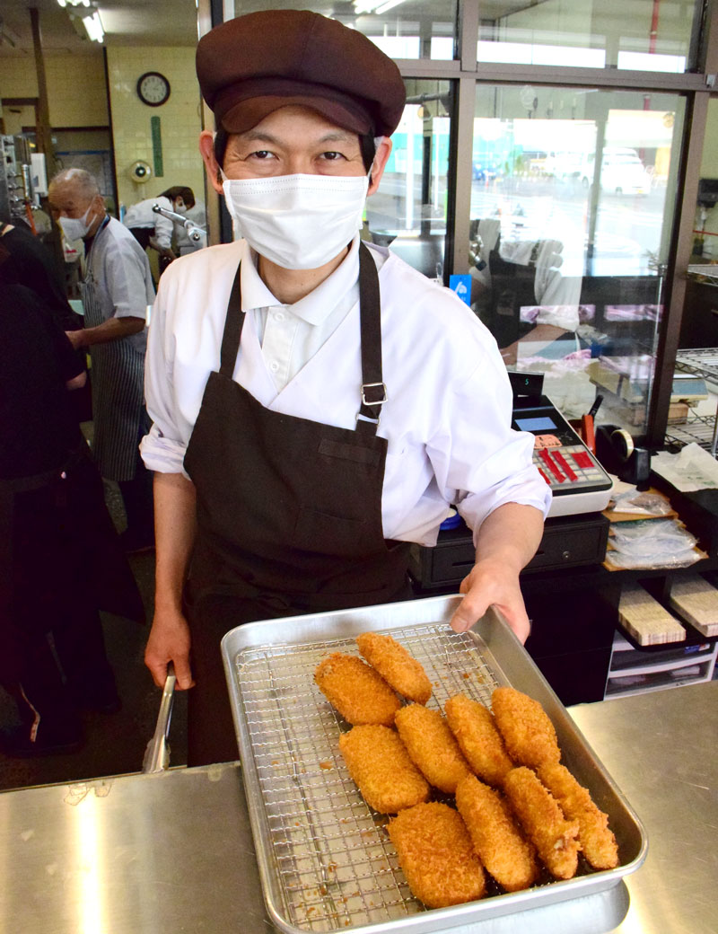 人気の昔ながらの自家製コロッケを見せる緑川さん