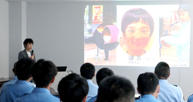 スクリーンに映し出された謙真君の写真の前で講演する高田さん=15日、千葉市中央区の県警本部交通合同庁舎