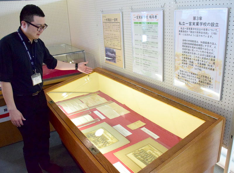 一宮商業高の創立100周年に合わせた企画展示を説明する担当者=一宮町中央公民館