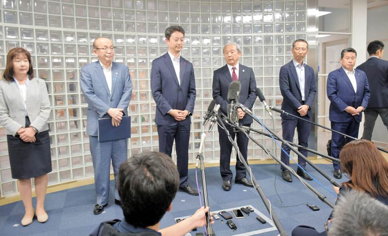 成田空港の滑走路新設・延伸に必要な用地確保推進に向けた協議会の会合後、報道陣の取材に応じるNAAの田村社長(右から3人目)や熊谷知事(同4人目)ら出席者=27日、成田市の同社