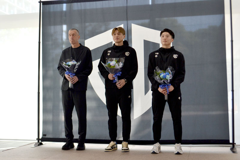 市職員から受け取った花束を手に初優勝と１部昇格を報告するアルティーリ千葉の大塚主将（中央）と黒川選手（右）、レマニス監督＝２８日、千葉市役所