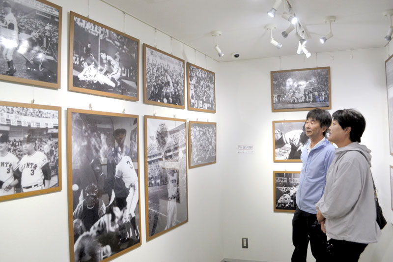 長嶋茂雄記念岩名球場内に設けられた展示室で長嶋さんの写真を見つめ、数々の功績に思いをはせるファン＝佐倉市